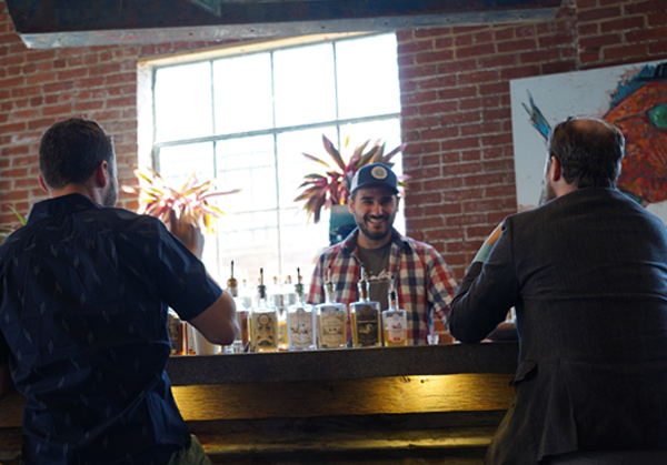 Two patrons sitting at the bar at the tasting room.